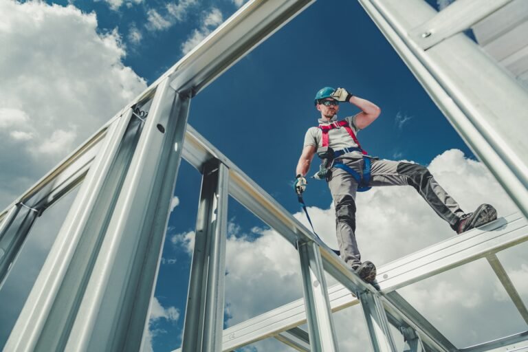 Working Using Safety Harness Shock Absorbing Lanyard and Safety Harness Equipment. Work at Height Safety. Caucasian Contractor on a Steel Building Frame.